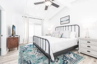 a bedroom with a bed and a ceiling fan at Remodeled 7Br Duplex Near Beach, Shops, And Dining By Beachview Rentals in Newport Beach