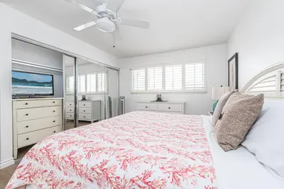 a white bedroom with a bed and a tv at 7Br Duplex W Oceanview Balcony And Ac, Walk To It All By Beachview Rentals in Newport Beach