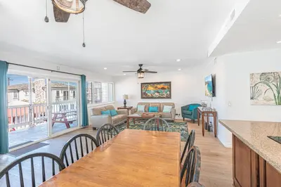 a dining room and living room with a table and chairs at 7Br Duplex W Oceanview Balcony And Ac, Walk To It All By Beachview Rentals in Newport Beach