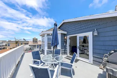 a patio with chairs and a table and an umbrella at 2Br Beach Escape W Oceanview Deck, 2 Houses From The Sand By Beachview Rentals in Newport Beach
