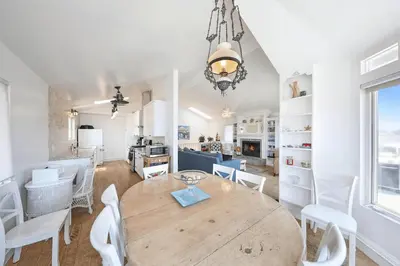 a kitchen and dining room with a wooden table and chairs at 2Br Beach Escape W Oceanview Deck, 2 Houses From The Sand By Beachview Rentals in Newport Beach