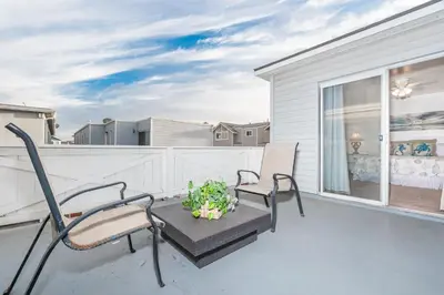 a balcony with two chairs and a plant on it at Spacious 4Br W Oceanview Balcony And Bbq, Steps To Sand By Beachview Rentals in Newport Beach
