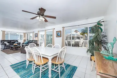 a dining room with a white table and chairs at Spacious 4Br W Oceanview Balcony And Bbq, Steps To Sand By Beachview Rentals in Newport Beach