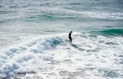 a man riding a wave on a surfboard in the ocean at Spacious 4Br W Oceanview Balcony And Bbq, Steps To Sand By Beachview Rentals in Newport Beach