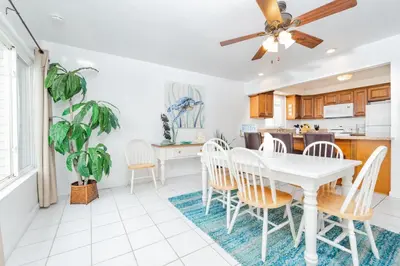 a kitchen and dining room with a white table and chairs at Spacious 4Br W Oceanview Balcony And Bbq, Steps To Sand By Beachview Rentals in Newport Beach
