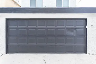 a black garage door on the side of a building at Stylish 6Br Duplex, One Block From Beach And Boardwalk By Beachview Rentals in Newport Beach