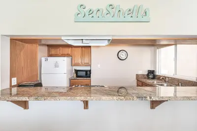 a kitchen with a counter top and a refrigerator at 3Br Oceanfront At Balboa Pier, Ac, Walk To It All By Beachview Rentals in Newport Beach