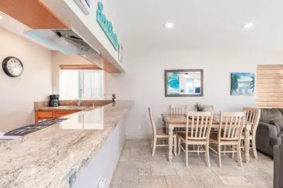 a kitchen and dining room with a table and chairs at 3Br Oceanfront At Balboa Pier, Ac, Walk To It All By Beachview Rentals in Newport Beach