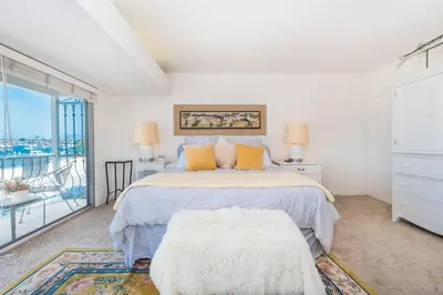 a white bedroom with a bed and a balcony at Spacious 3Br Bayfront W Harbor Views, Walk To Beach By Beachview Rentals in Newport Beach