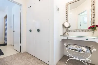 a white hallway with a mirror and a chair at Spacious 3Br Bayfront W Harbor Views, Walk To Beach By Beachview Rentals in Newport Beach