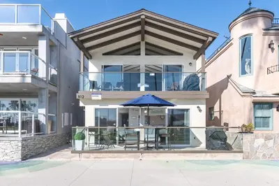 a house with a patio with an umbrella at 3Br Oceanfront At Balboa Pier W Ac And Great Walkability By Beachview Rentals in Newport Beach