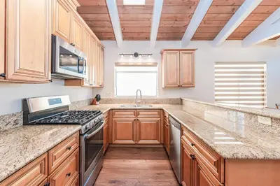a kitchen with wooden cabinets and a stove top oven at 3Br Oceanfront At Balboa Pier W Ac And Great Walkability By Beachview Rentals in Newport Beach