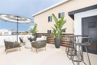 a patio with chairs and a table and an umbrella at Luxury 6Br Triplex In Prime Location One House From Sand By Beachview Rentals in Newport Beach