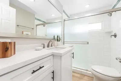 a white bathroom with a sink and a toilet at Luxury 6Br Triplex In Prime Location One House From Sand By Beachview Rentals in Newport Beach
