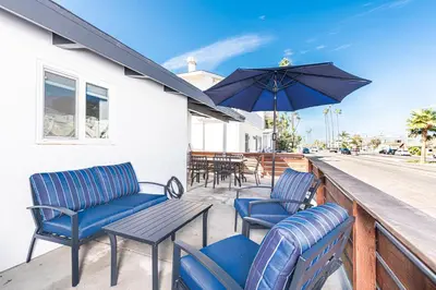 a patio with chairs and a table and an umbrella at Luxury 6Br Triplex In Prime Location One House From Sand By Beachview Rentals in Newport Beach