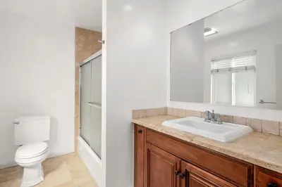 a bathroom with a sink and a toilet and a mirror at 5Br Coastal Retreat W Ocean Views - Steps From Beach By Beachview Rentals in Newport Beach