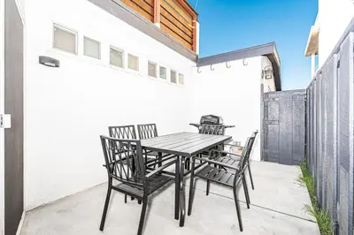 a wooden table and chairs on a patio at Updated 2Br Cottage One House From Beach - Super Central By Beachview Rentals in Newport Beach