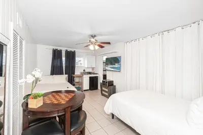 a bedroom with two beds and a table with a chessboard at Affordable Studio, Steps From Beach And Marina Park By Beachview Rentals in Newport Beach