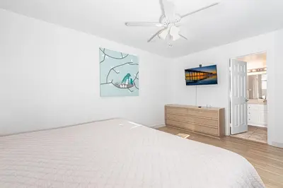 a white bedroom with a bed and a ceiling fan at Epic 7Br Retreat W Oceanview Rooftop Deck - Steps To Sand By Beachview Rentals in Newport Beach