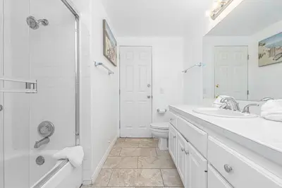 a white bathroom with two sinks and a shower at Epic 7Br Retreat W Oceanview Rooftop Deck - Steps To Sand By Beachview Rentals in Newport Beach