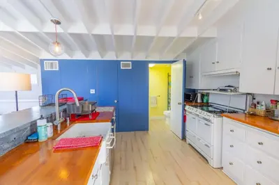 a kitchen with blue walls and white cabinets at The Lantern House, Walk to Harbor, Great Outdoors in Dana Point