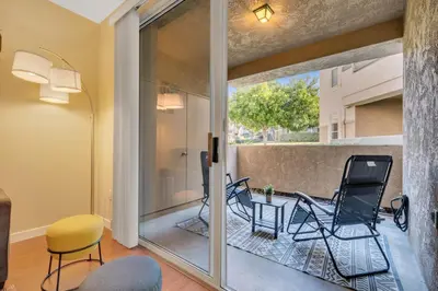 a room with a balcony with chairs and a table at Heart of Carmel Valley 2BR, Families and Corp Stays in San Diego