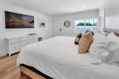 a white bedroom with a large white bed with pillows at Stunning 3BR Capo Beach Home with Ocean Views in Dana Point