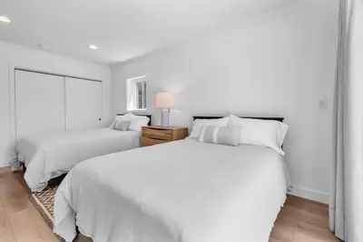a white bedroom with two beds and a window at Stunning 3BR Capo Beach Home with Ocean Views in Dana Point