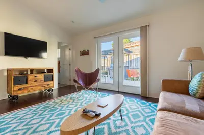 a living room with a couch and a tv at San Diego Staycation Home with Hot Tub Ocean Views in Encinitas