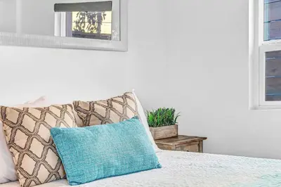 a blue pillow sitting on top of a bed at North Park 1BR Cottage Prime Location with Parking in San Diego