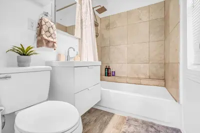 a bathroom with a toilet and a tub and a sink at North Park 1BR Cottage Prime Location with Parking in San Diego