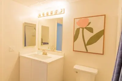 a bathroom with a sink and a mirror and a toilet at Modern Downtown SD Apartment Stunning City Views in San Diego