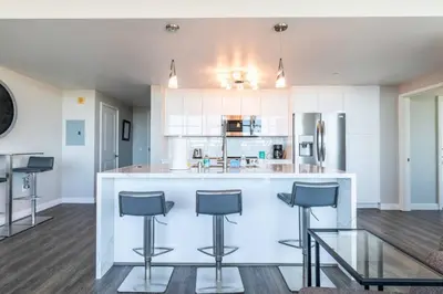 a kitchen with a counter and stools in a room at Modern Downtown SD Apartment Stunning City Views in San Diego