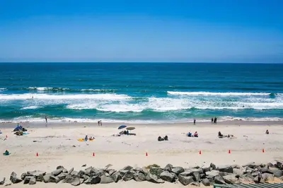 a group of people on a beach near the ocean at Staycation Beach Family Home Great Indoor Outdoor in Carlsbad
