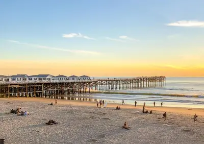 a group of people on the beach near a pier at Pacific Beach Cottage 1 Walk to the Beach and Bay in San Diego