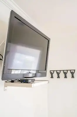 a flat screen tv sitting on top of a white wall at Pacific Beach Cottage 3 Walk to the Beach and Bay in San Diego