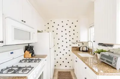 a white kitchen with black stars on the wall at Pacific Beach Cottage 2 Walk to the Beach and Bay in San Diego
