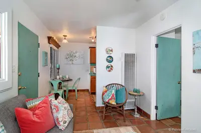 a living room with a couch and a table at Cute Old Town Cottage near Downtown Beaches in San Diego