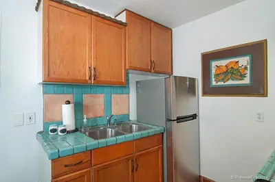a kitchen with a sink and a refrigerator at Cute Old Town Cottage near Downtown Beaches in San Diego