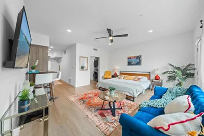 a living room with a blue couch and a tv at Stylish Top-Floor Gem with King Bed & City Ocean Views in San Diego