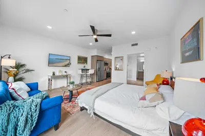 a bedroom with a large bed and a blue couch at Stylish Top-Floor Gem with King Bed & City Ocean Views in San Diego