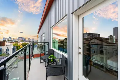 a balcony with two chairs and a view of the city at Stylish Top-Floor Gem with King Bed & City Ocean Views in San Diego