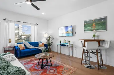 a living room with a blue couch and a table at Stylish Top-Floor Gem with King Bed & City Ocean Views in San Diego