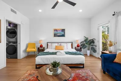a bedroom with a bed and a blue couch at Stylish Top-Floor Gem with King Bed & City Ocean Views in San Diego