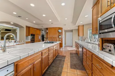 a large kitchen with wooden cabinets and white counter tops at Lakeside Mansion Waterfront 34 beds Boat ramp in Lake Elsinore