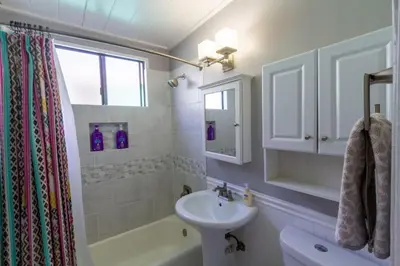 a white bathroom with a sink and a toilet at Cozy Ocean Beach Cottage Separate Entry in San Diego