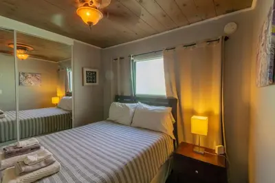 a small bedroom with two beds and a mirror at Cozy Ocean Beach Cottage Separate Entry in San Diego