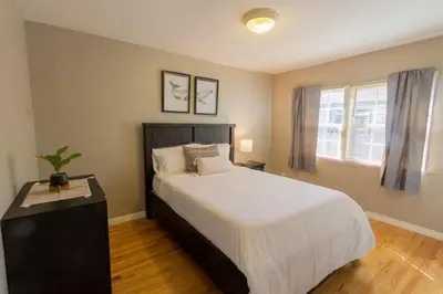 a bedroom with a large white bed and a window at Centrally Located Cottage Near Lake Trails Shops in La Mesa