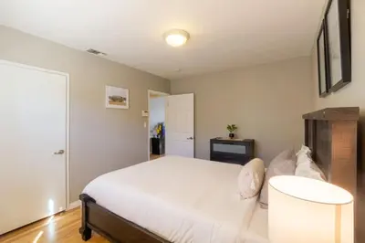 a bedroom with a white bed and a table at Centrally Located Cottage Near Lake Trails Shops in La Mesa