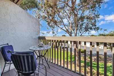 a patio with a table and chairs on a deck at 2BR Condo with Views Near Shops and Food, Fast WiFi in Carlsbad